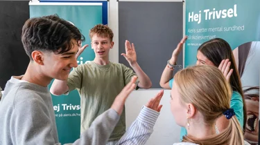 Billede af elever fra 8. klasse, der giver hinanden high five, mens de spiller Trivselsspillet.