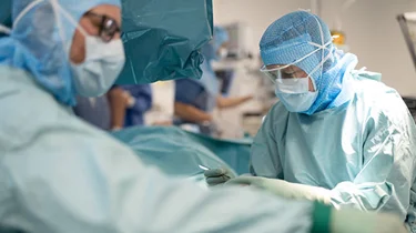 Kvindelig og mandelig læge fra Aleris Danmark under en operation.