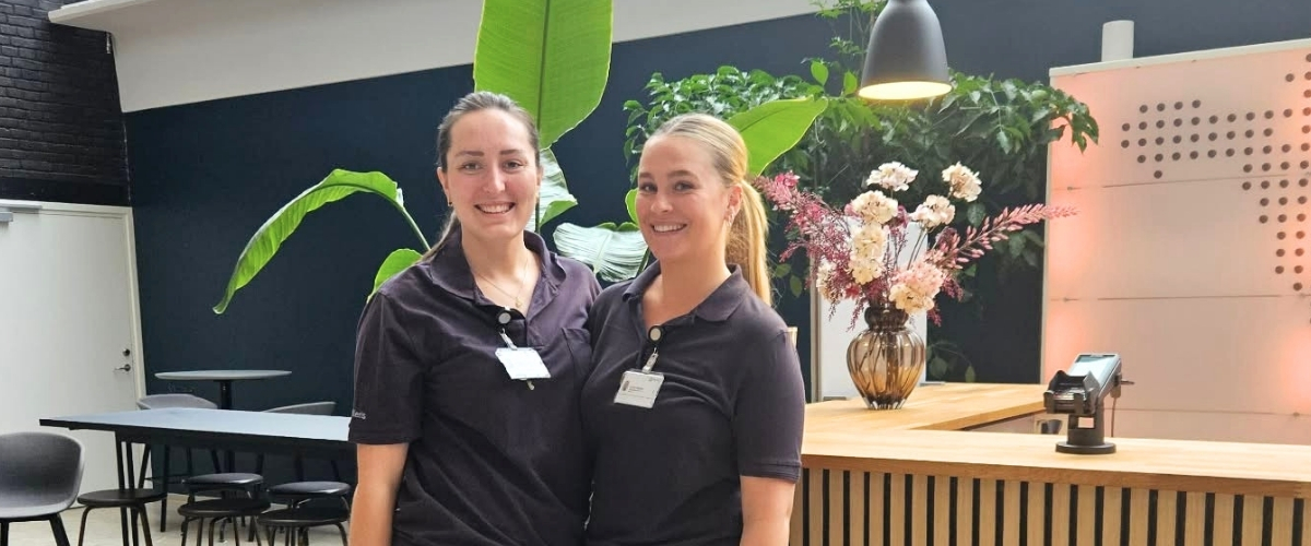 Et billede af to sygeplejestuderende i receptionen hos Aleris København 