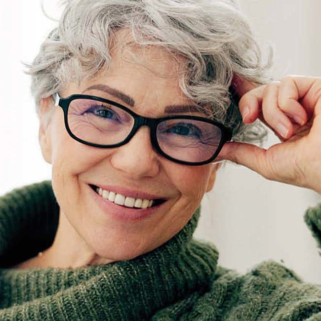 Smilende kvinde med briller.