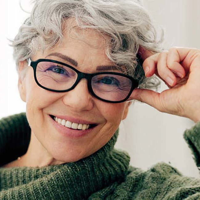 Smilende kvinde med briller.