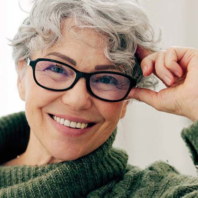 Smilende kvinde med briller.