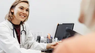 Læge smiler til sin patient.