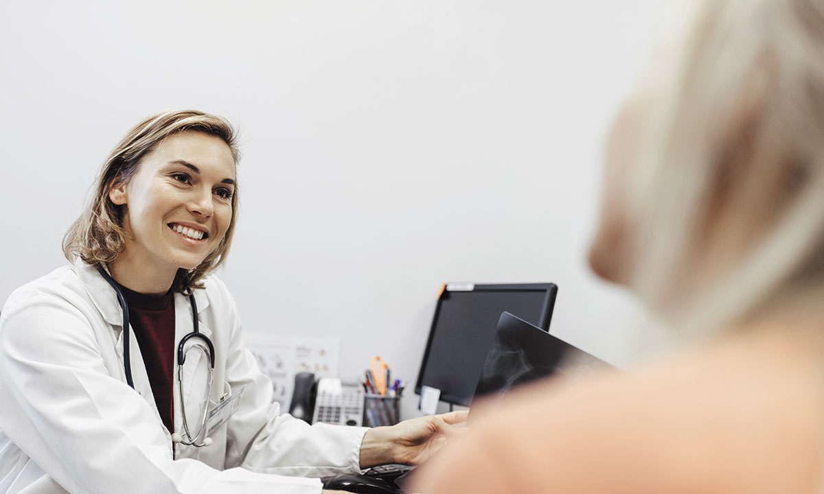 Gynækolog taler med sin patient ved en konsultation.