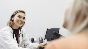 Gynækolog taler med sin patient ved en konsultation.