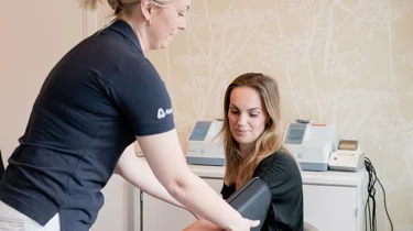 Helbredssygeplejerske tager blodtryk på patient.