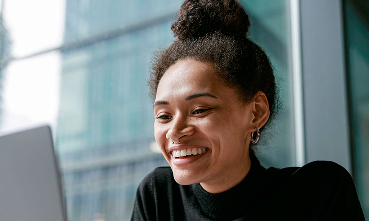 Smilende kvinde har en online samtale på en computer.