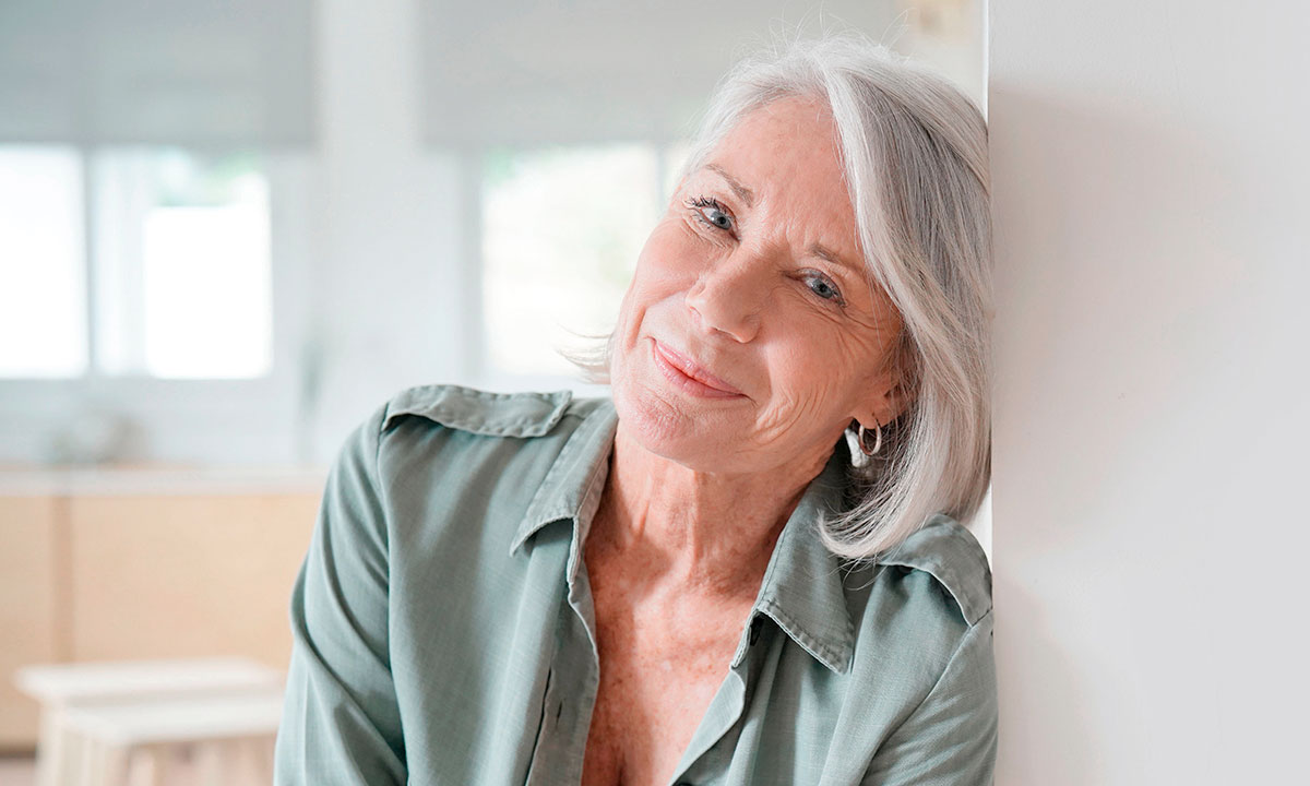 Midaldrende kvinde smiler ind i kameraet.