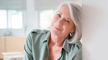 Midaldrende kvinde smiler ind i kameraet.