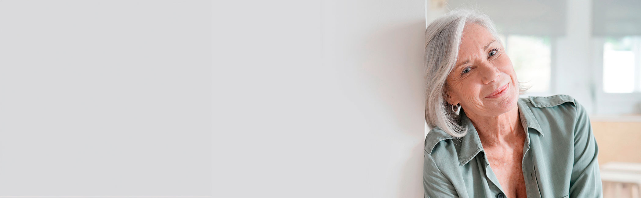 Midaldrende kvinde smiler ind i kameraet.