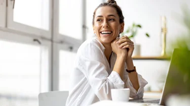 Smilende kvinde ser sig over skulderen og ud af vinduet.