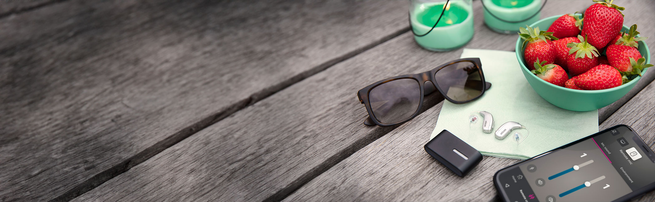 Oticon miniRITE høreapparat ligger på bord sammen med en ConnectClip og iPhone