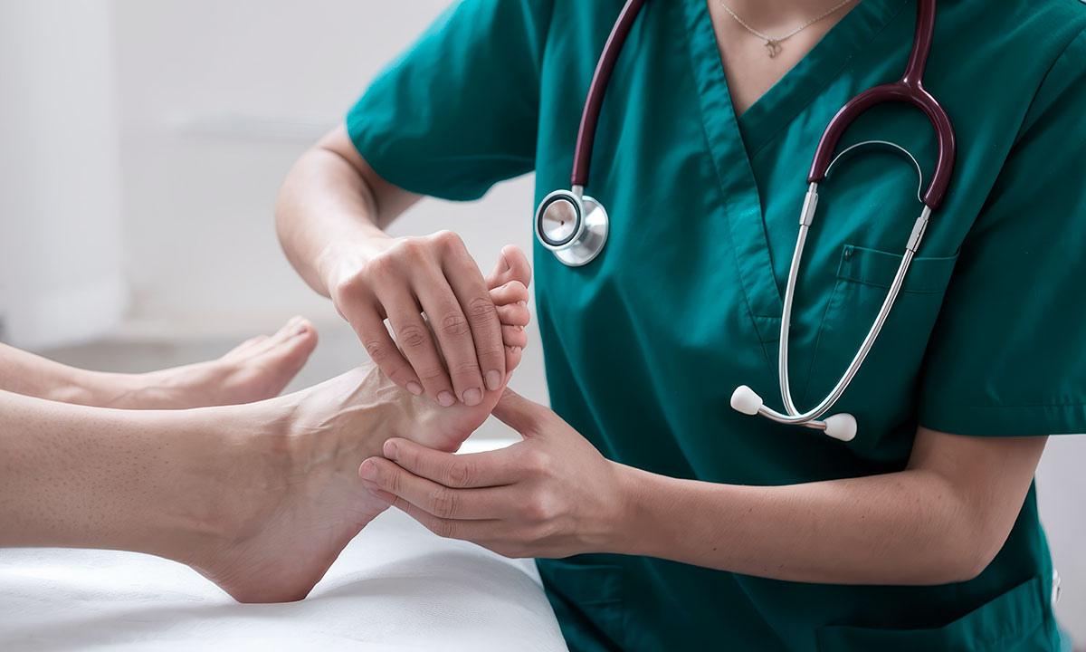 Læge undersøger storetåen for slidgigt.