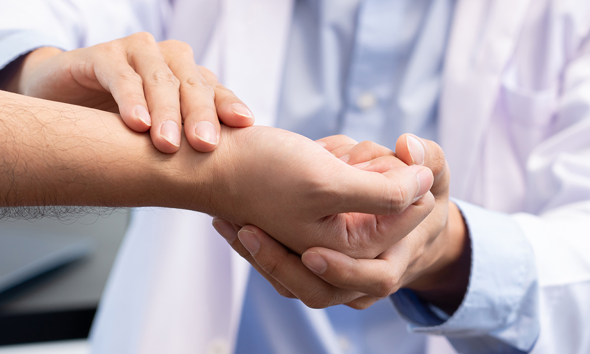 Læge undersøger håndled for karpaltunnelsyndrom.