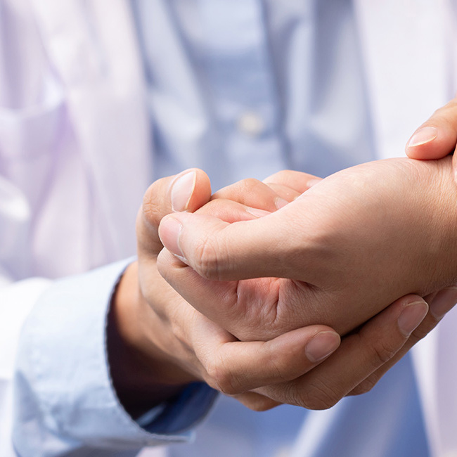 Læge undersøger håndled for karpaltunnelsyndrom.
