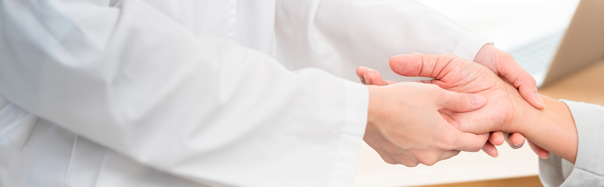 Håndkirurg undersøger en patients hånd.