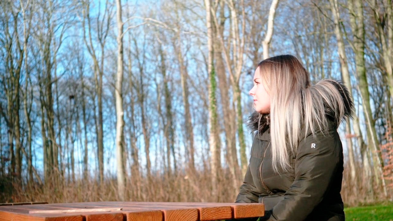 Ung kvinde går i en skov.