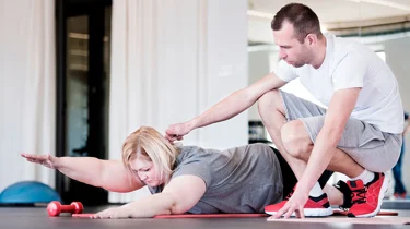 Fysioterapeut i Aleris vejleder overvægtspatient i optimal træning.