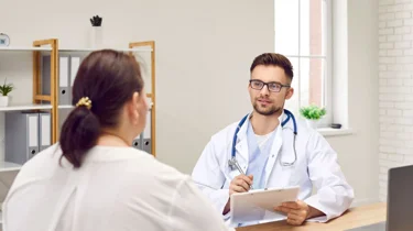 Overvægtig kvinde sidder til en konsultation hos lægen.