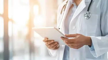 En læge står med en patientplan på et af Aleris hospitaler.