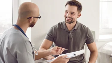 Læge taler med patient ved en konsultation.